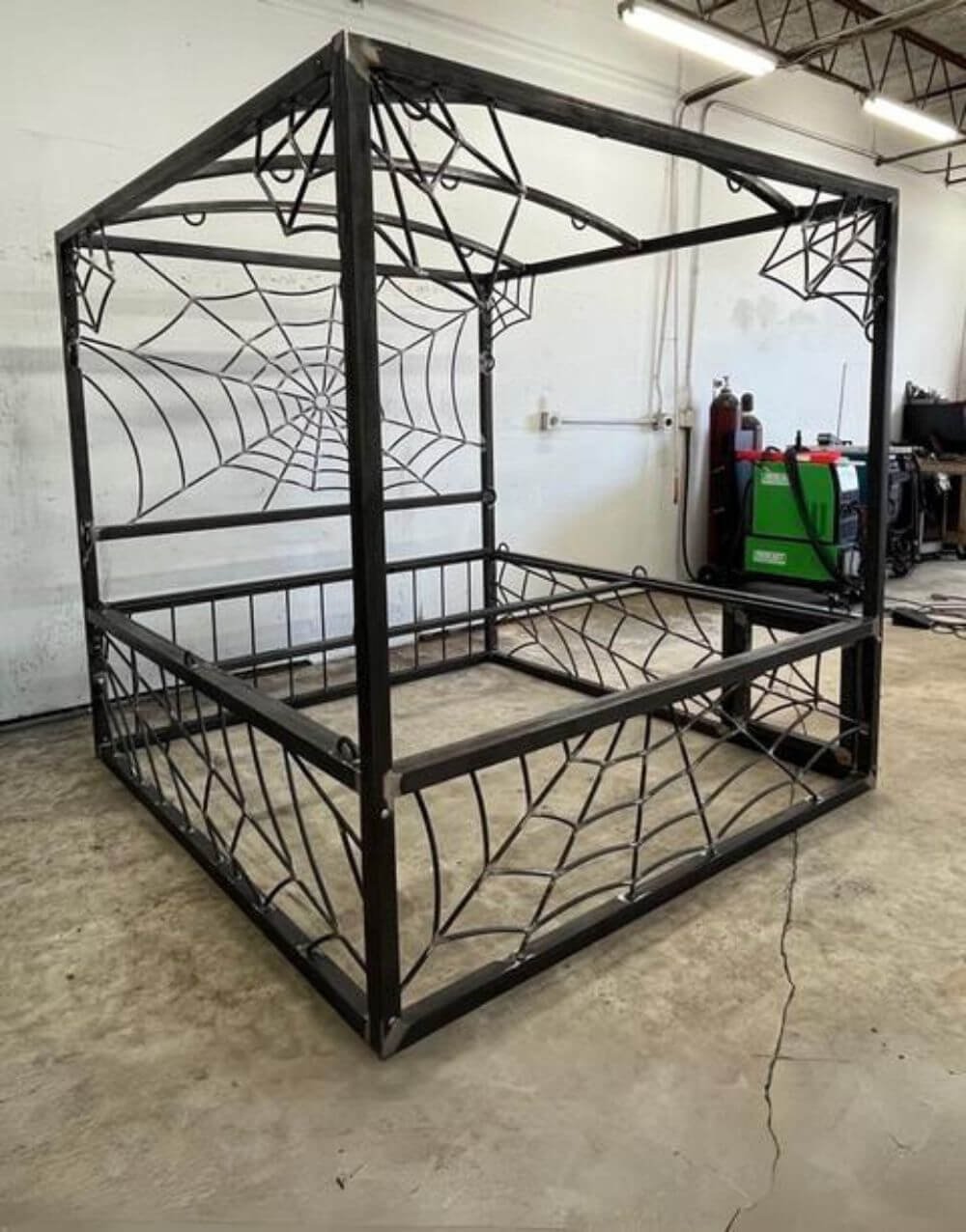 Spider Bed by Metalbound: a distinctive metal bed frame with a spiderweb design, offering multiple attachment points for secure and versatile bondage play.