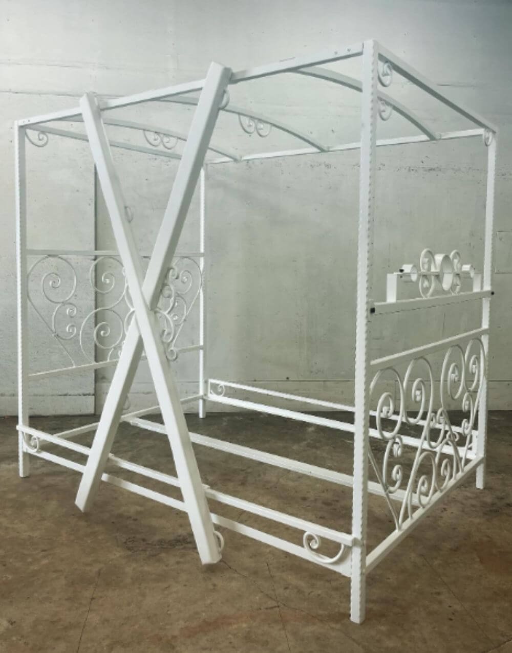 Elegant Scroll Bed in White by Metalbound featuring hand-crafted steel scrolls and versatile attachment points for BDSM play.