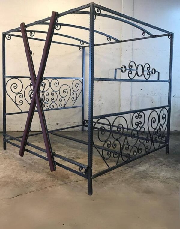 Scroll Bed by Metalbound featuring hand-crafted steel scrolls and a removable burgundy cross for versatile BDSM play.
