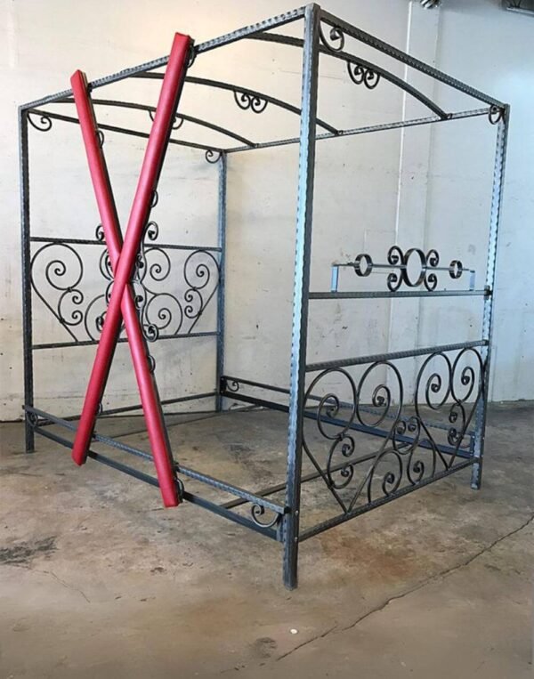 Scroll Bed by Metalbound featuring hand-crafted steel scrolls and a removable red cross for versatile BDSM play.