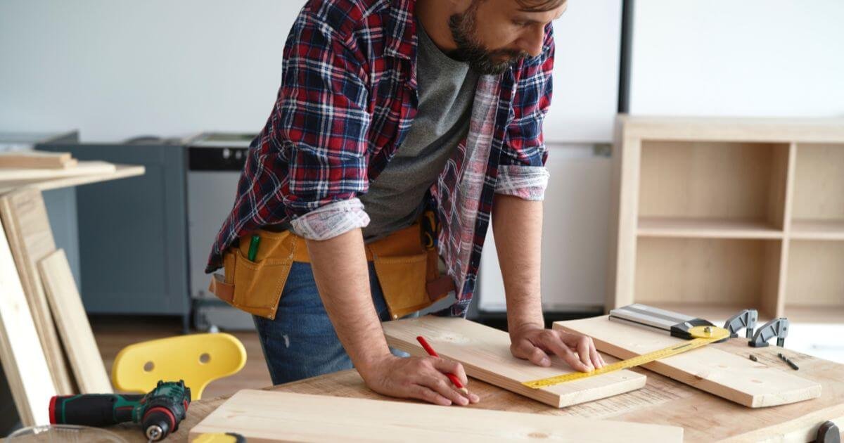 A man wearing flannel building homemade sex furniture.